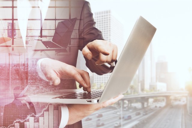 Geöffneter Laptop auf dem zwei Hände etwas zeigen